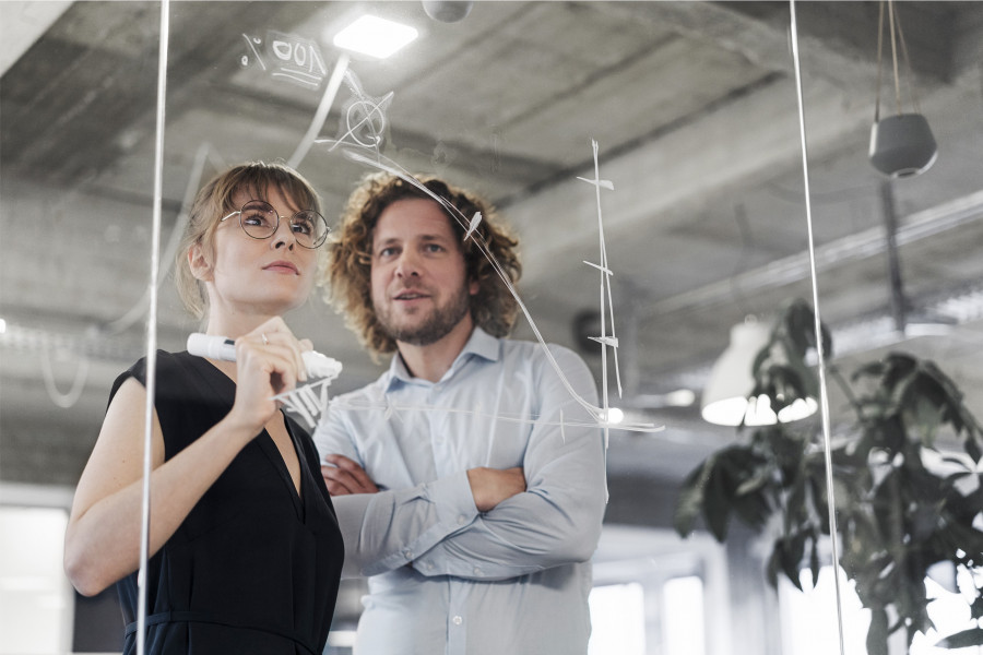 Two people in front of a whiteboard