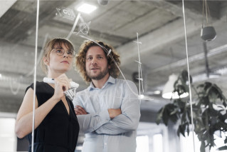 Two people in front of a whiteboard