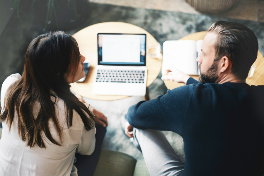 Two people sitting in front of a laptop