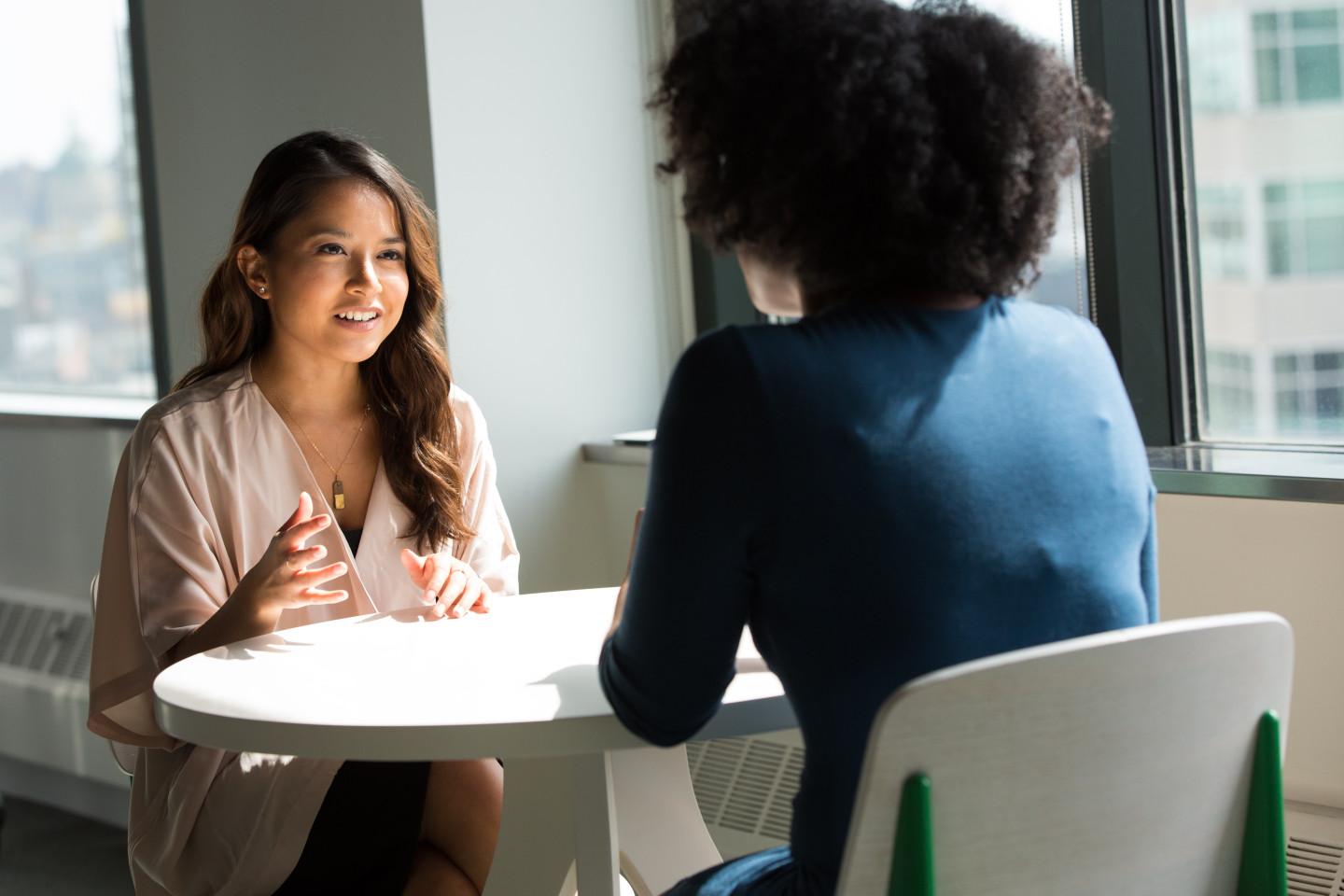 Two people having a friendly conversation at a round table.