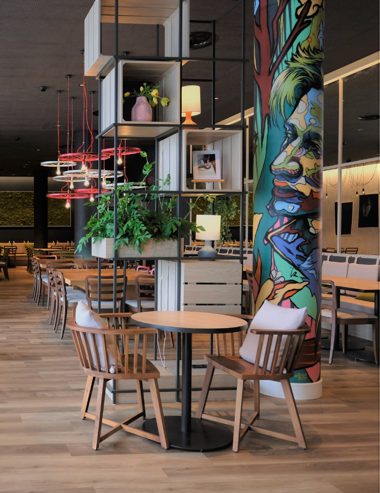 A man is sitting on a table in the modern lounge area of an IntercityHotel.