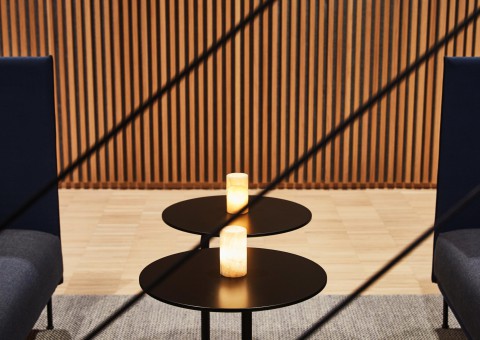 detail shot of a small, round coffee table between two couches.